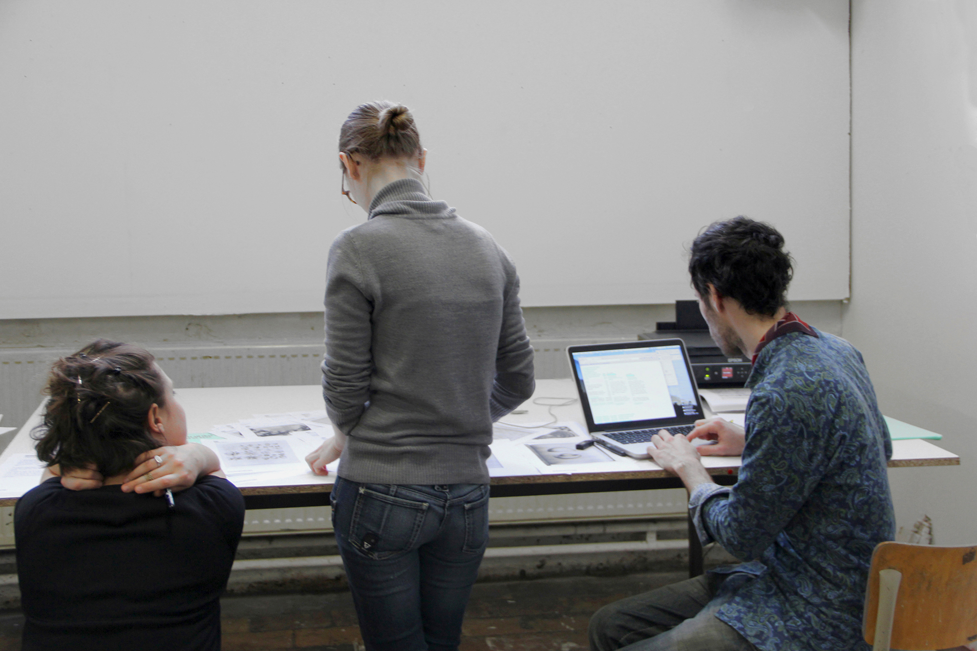 Photographie d'un workshop: participants autour d'un ordinateur et d'une imprimante